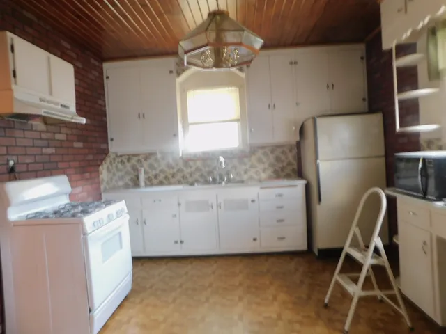 a kitchen with granite countertop white cabinets and white appliances