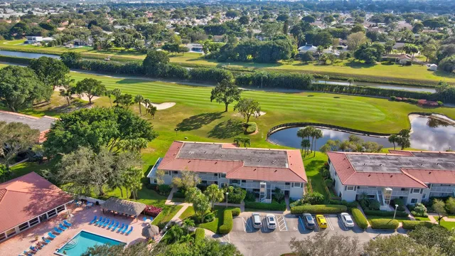 an aerial view of a house with a yard and tennis court