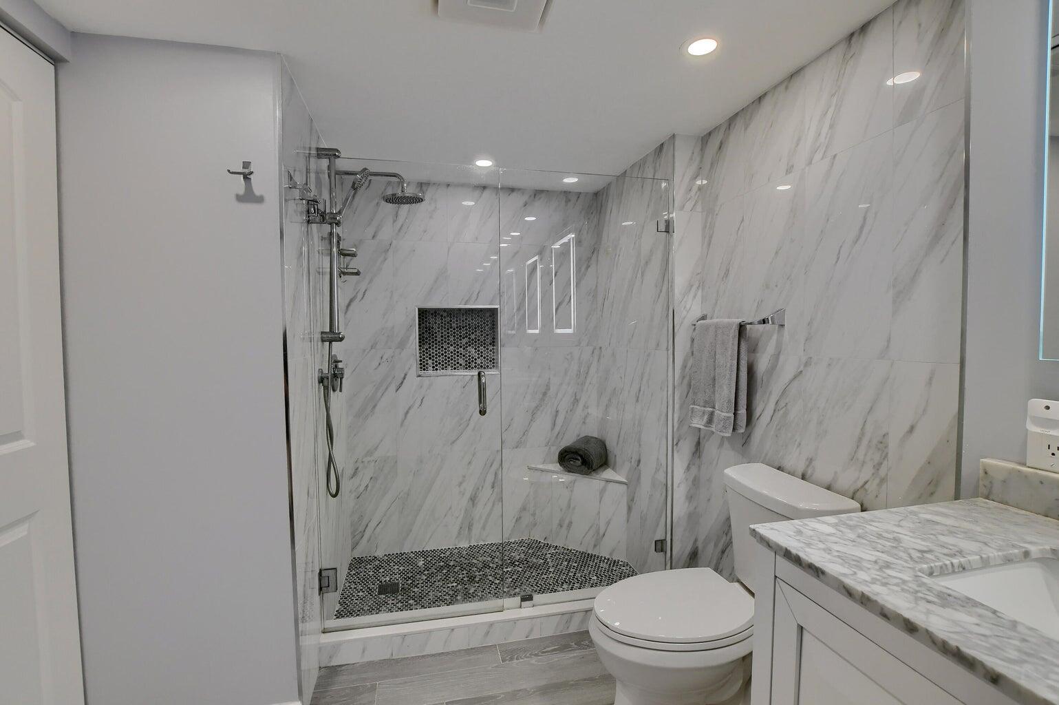 14 Southport Lane, Unit C Boynton Beach, FL 33436 - Photo 2 of 39 a bathroom with a granite countertop sink toilet and shower