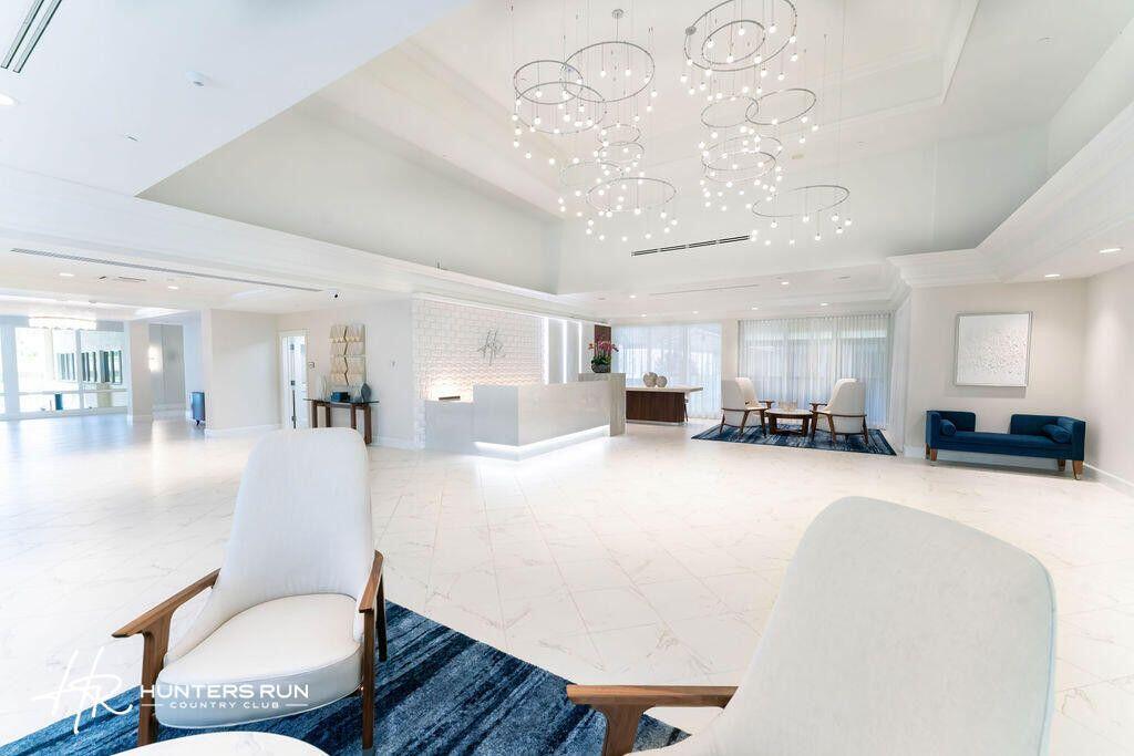 14 Southport Lane, Unit C Boynton Beach, FL 33436 - Photo 38 of 39 a living room with furniture and a chandelier