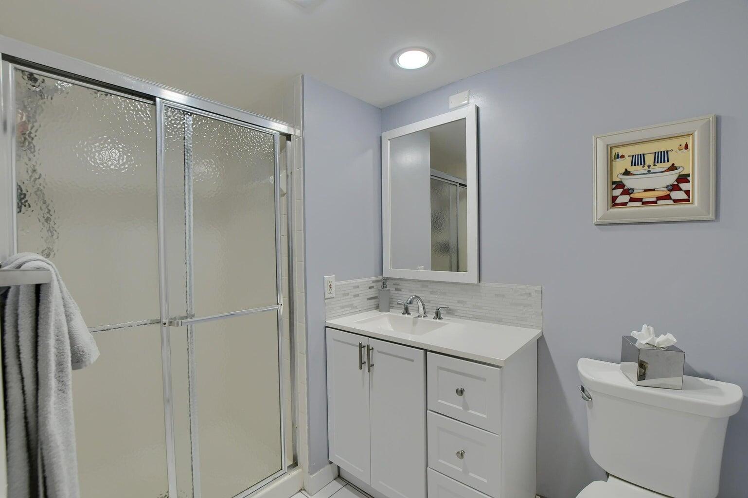 14 Southport Lane, Unit C Boynton Beach, FL 33436 - Photo 6 of 39 a bathroom with a sink toilet and mirror