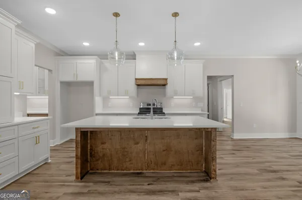 a view of a kitchen counter top space a sink wooden floor and kitchen view