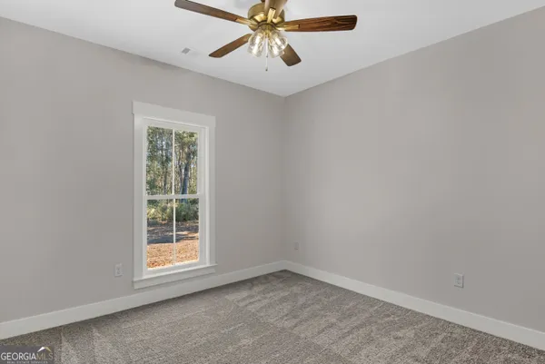 an empty room with windows and fan