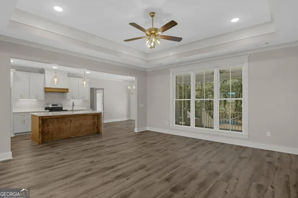 a view of an empty room with window and wooden floor