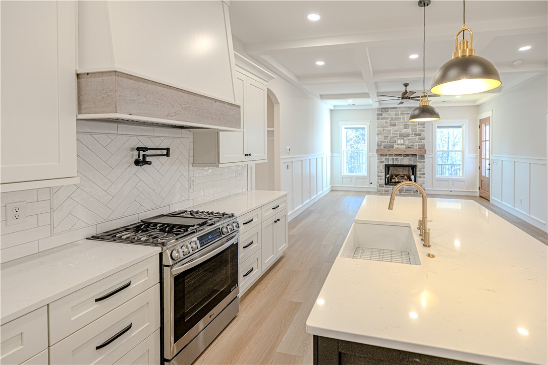 1409 Stonehurst Road Anderson, SC 29621 - Photo 21 of 37 This bright kitchen and living area features a fireplace and spacious island, perfect for entertaining.