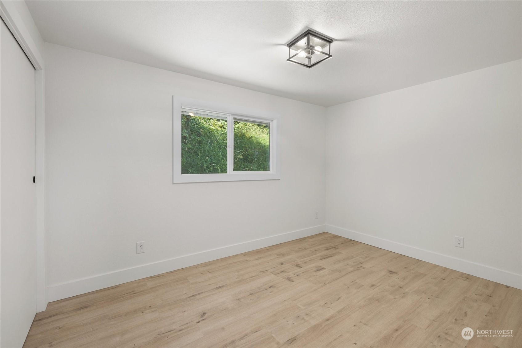 6314 Larimer Road Everett, WA 98208 - Photo 22 of 40 an empty room with wooden floor and windows