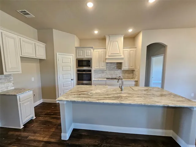 a living room with stainless steel appliances kitchen island granite countertop furniture a fireplace and a flat screen tv