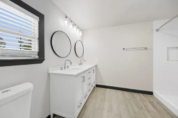 a bathroom with a double vanity sink and a mirror