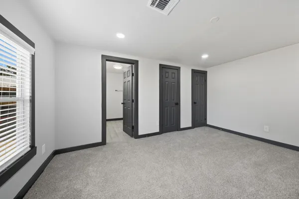a view of empty room with wooden floor and windows