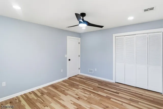 a view of room with wooden floor and ceiling fan