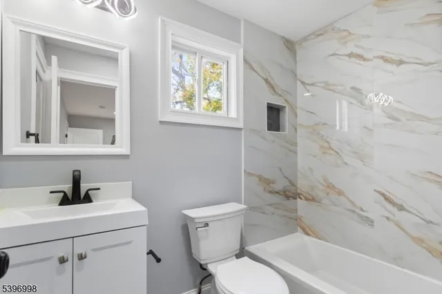 a bathroom with a toilet sink and mirror