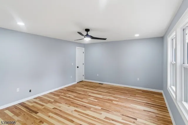 a view of a room has a window and a ceiling fan