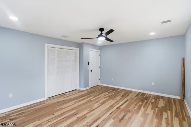 a view of a room with a wooden floor and a ceiling fan