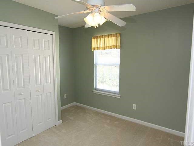 5012 Gable Ridge Drive Durham, NC 27713 - Photo 8 of 12 an empty room with a window and chandelier fan