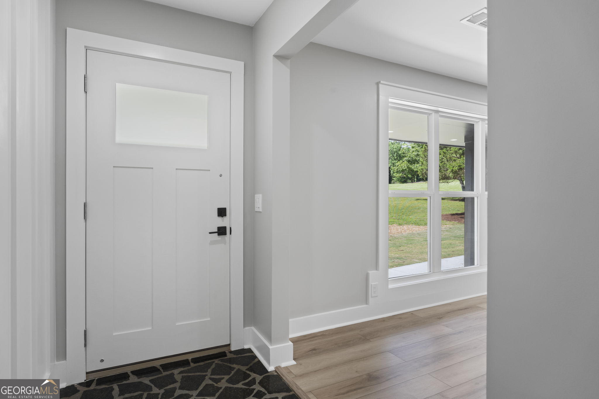 2604 Flat Shoals Road Southwest Conyers, GA 30094 - Photo 16 of 44 a view of an empty room with wooden floor and a window