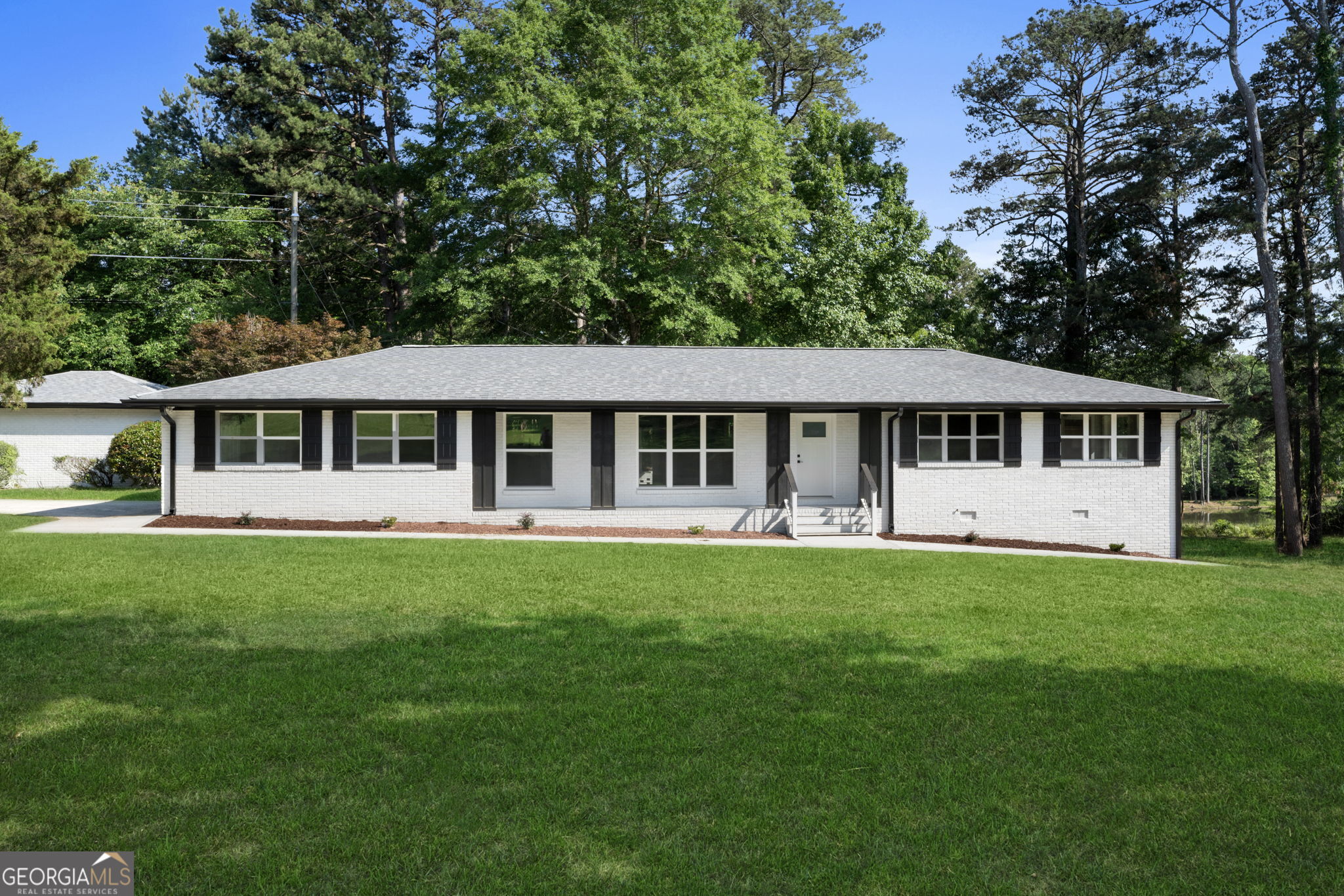 2604 Flat Shoals Road Southwest Conyers, GA 30094 - Photo 3 of 44 a front view of a house with a garden