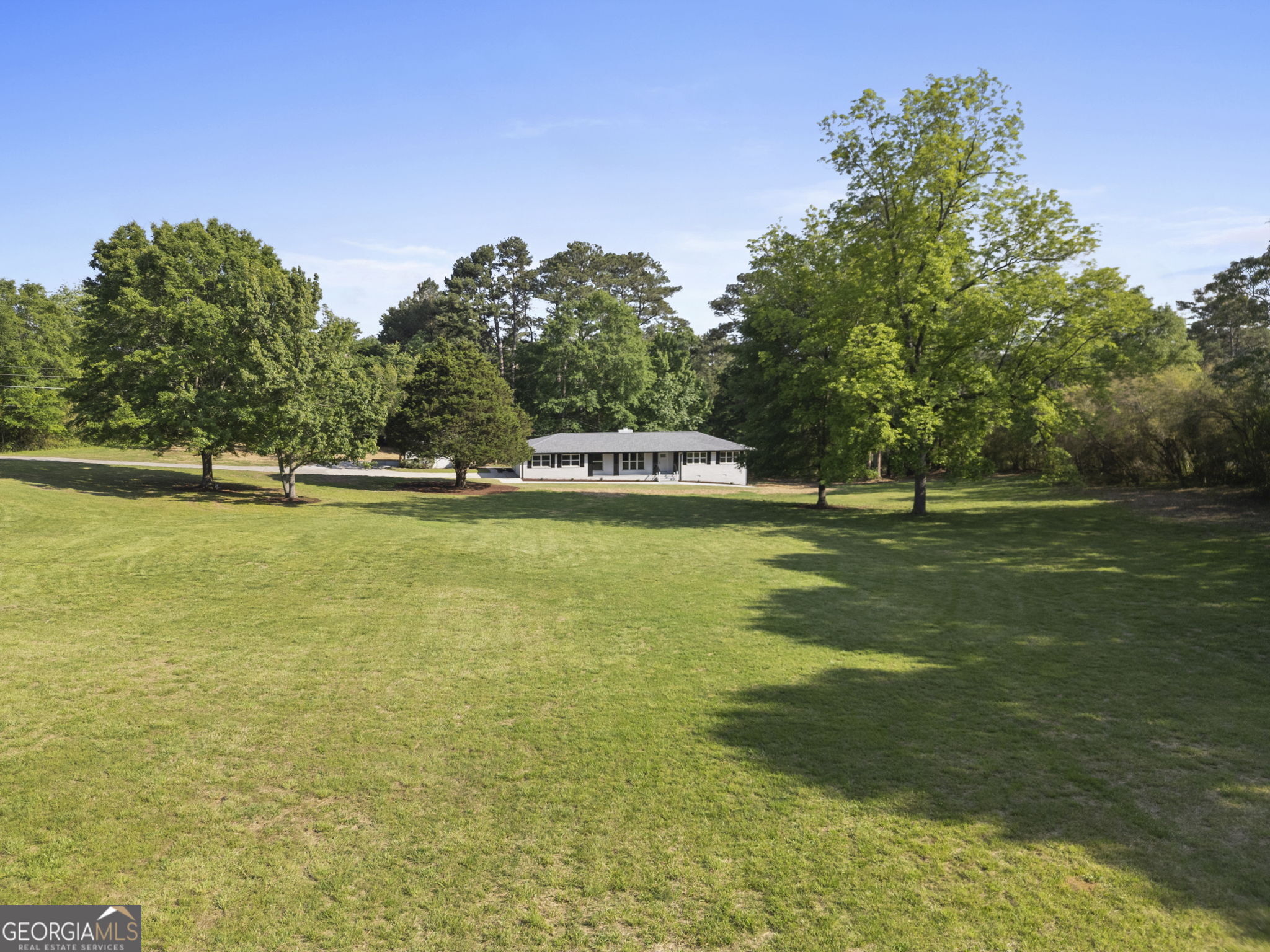 2604 Flat Shoals Road Southwest Conyers, GA 30094 - Photo 4 of 44 a view of yard with swimming pool and trees in the background