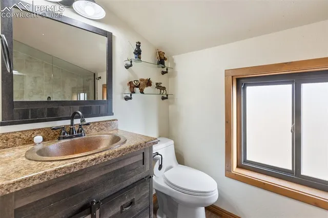 a bathroom with a granite countertop toilet sink and mirror