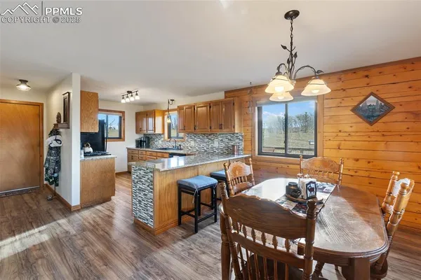 a view of a dining room and livingroom with furniture wooden floor a chandelier