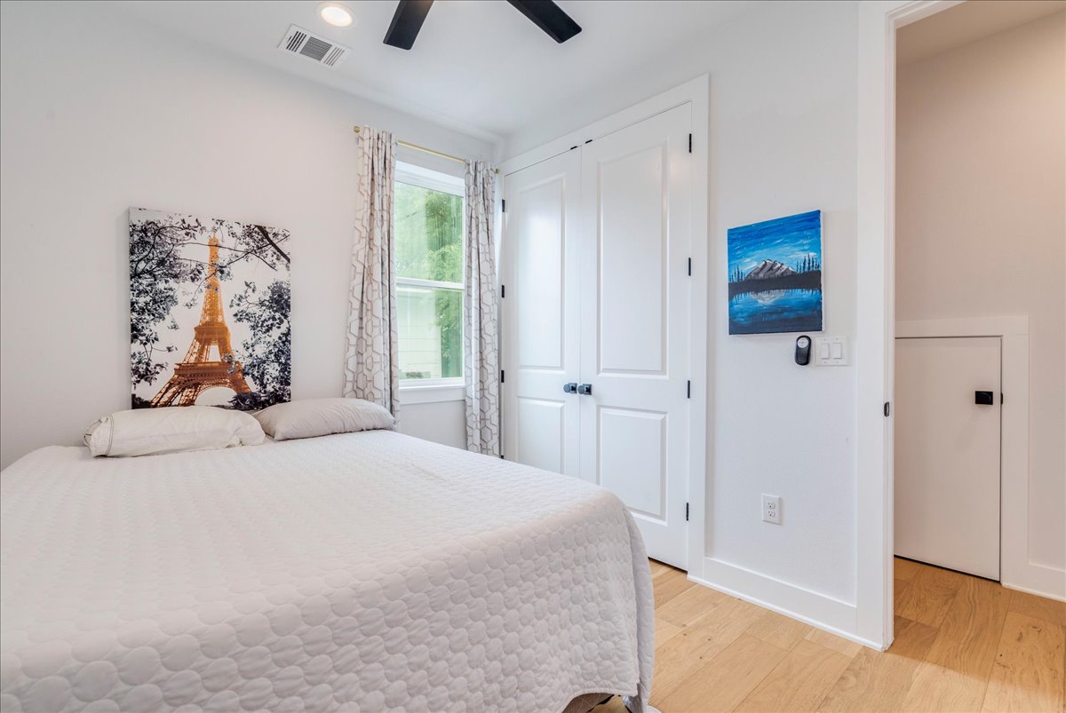 1214 Delano Street, Unit 1 Austin, TX 78721 - Photo 13 of 27 a bedroom with a large bed and a chandelier