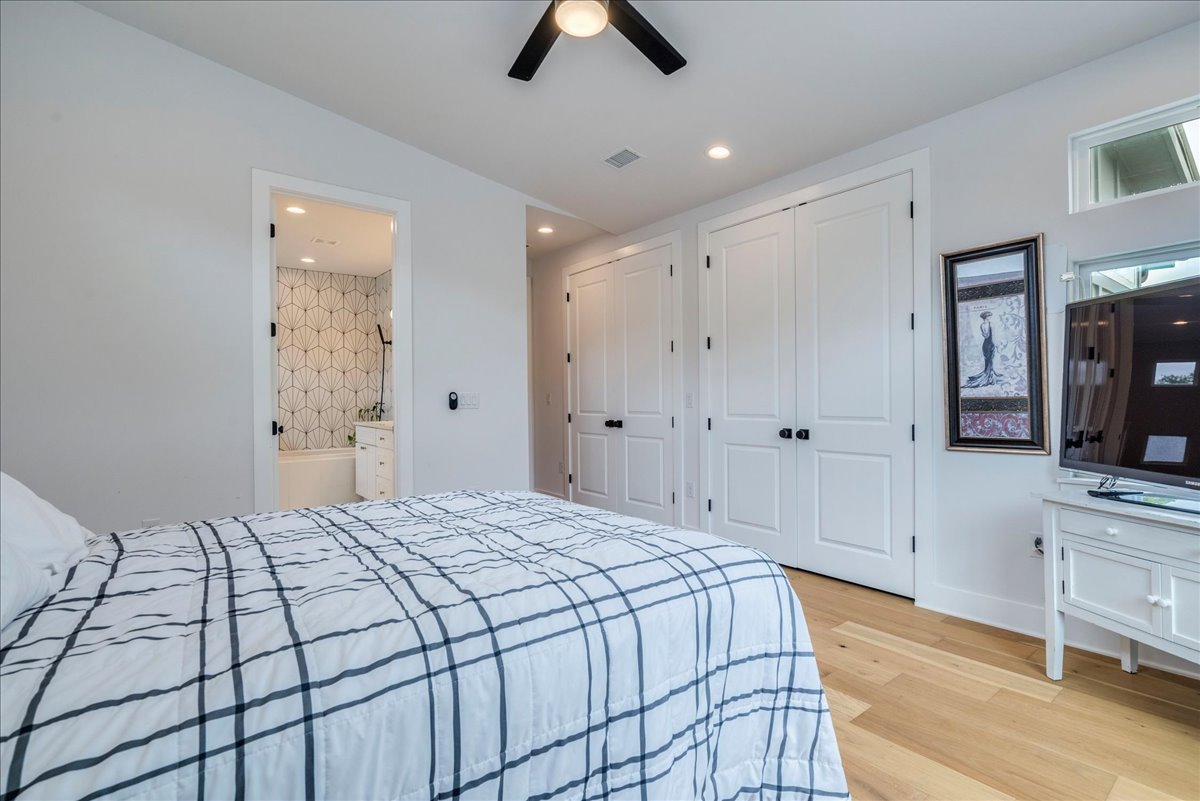 1214 Delano Street, Unit 1 Austin, TX 78721 - Photo 15 of 27 a spacious bedroom with a bed and a chandelier