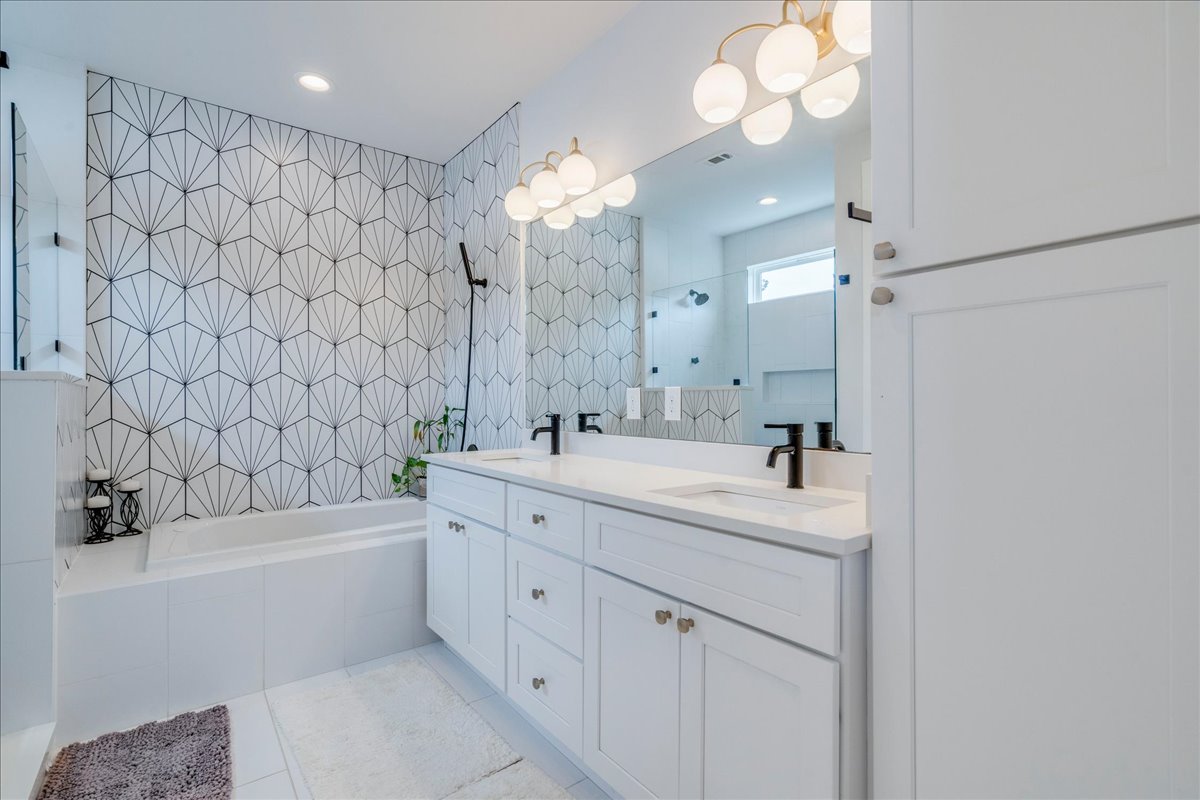 1214 Delano Street, Unit 1 Austin, TX 78721 - Photo 16 of 27 a bathroom with a double vanity sink mirror and shower