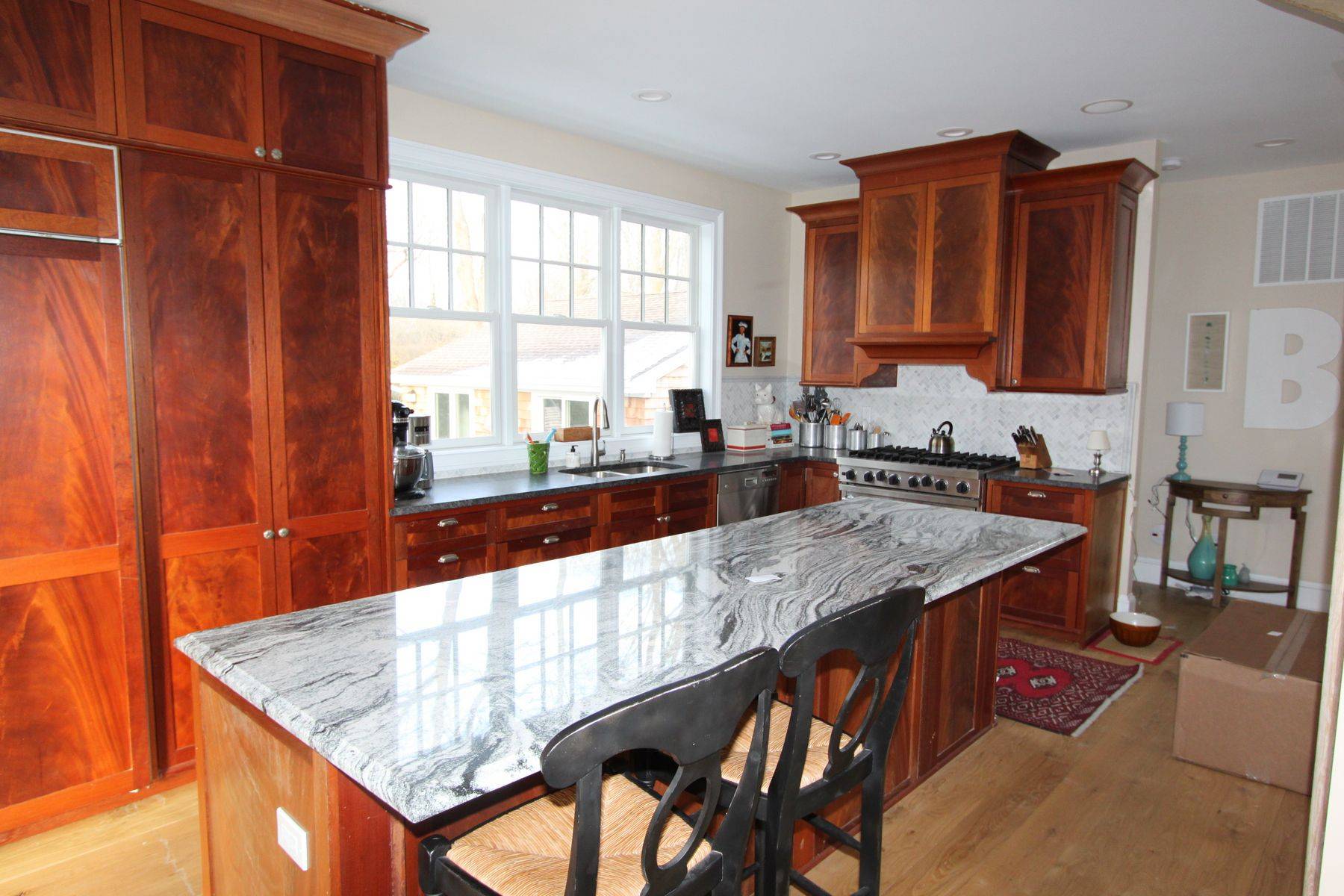 7 School Street Bridgehampton, NY 11932 - Photo 4 of 7 a kitchen with stainless steel appliances granite countertop a sink and cabinets