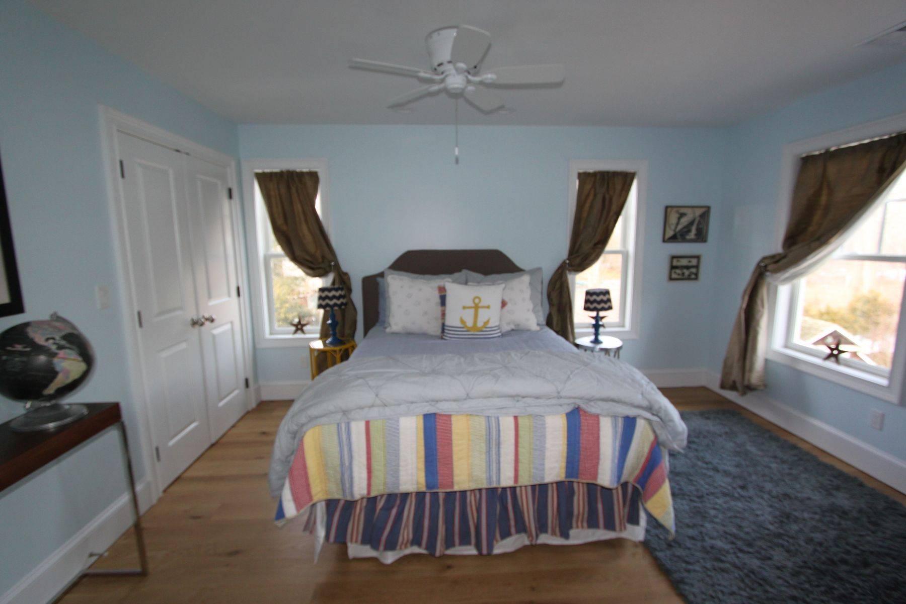 7 School Street Bridgehampton, NY 11932 - Photo 7 of 7 a bedroom with a bed next to a window with a flat screen tv