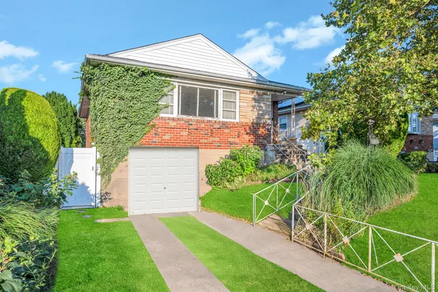 a front view of a house with a yard and potted plants