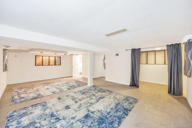 a view of a big room with window and wooden floor