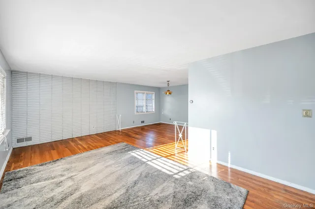 a view of a room with wooden floor and a rug