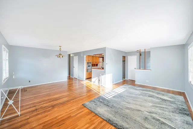 a view of a livingroom with wooden floor and a ceiling fan