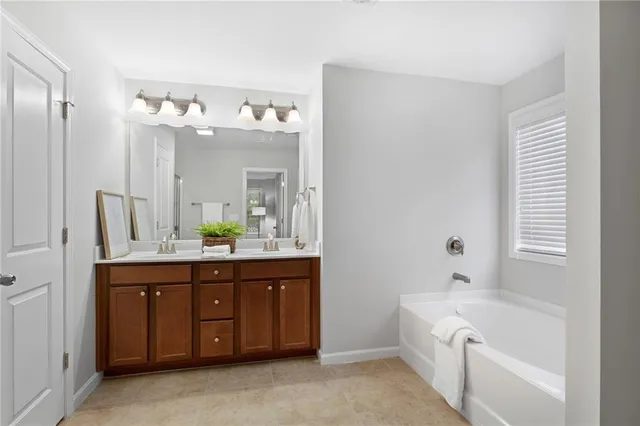 a spacious bathroom with a tub sink and mirror