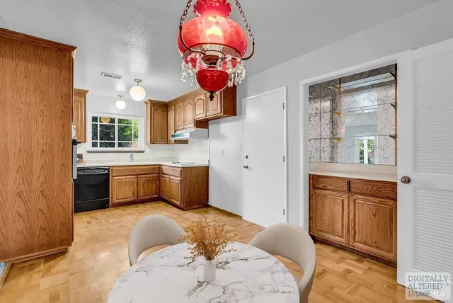 a kitchen with stainless steel appliances kitchen island granite countertop a sink dishwasher a refrigerator with a dining table and chairs