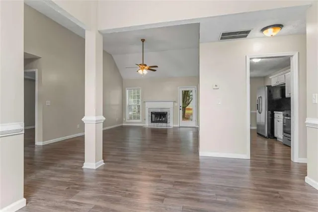 a view of a livingroom with wooden floor and a fireplace