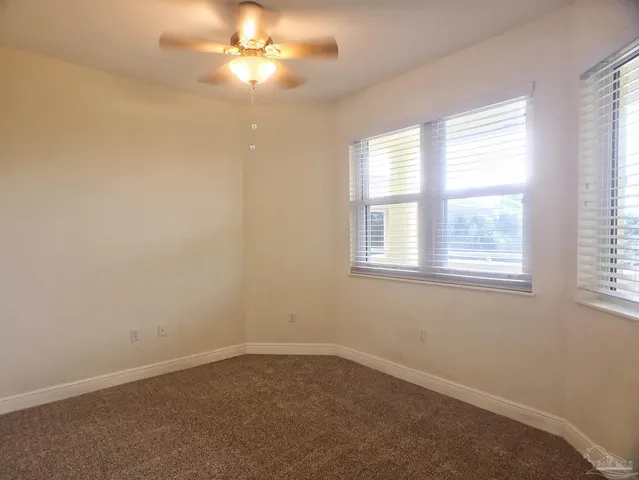 an empty room with a window and a fan