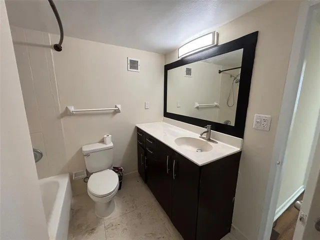 a bathroom with a sink vanity and a toilet