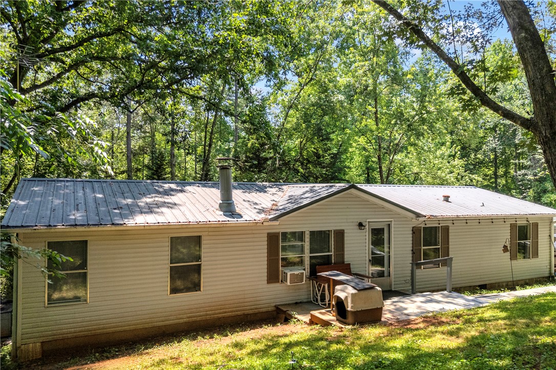 162 Newberry Road Walhalla, SC 29691 - Photo 46 of 50 A metal roof crowns this charming siding home, nestled amidst a verdant tree line.