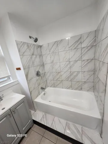 a bathroom with bathtub and shower