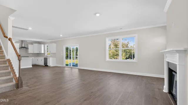 a view of a big room with wooden floor and windows