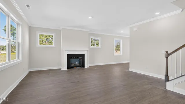an empty room with windows and fireplace