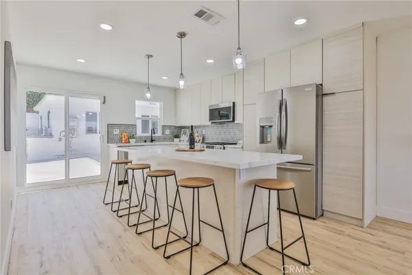 a living room with furniture and a dining table with kitchen view