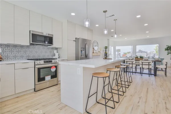 a kitchen with stainless steel appliances kitchen island a refrigerator and a wooden cabinets