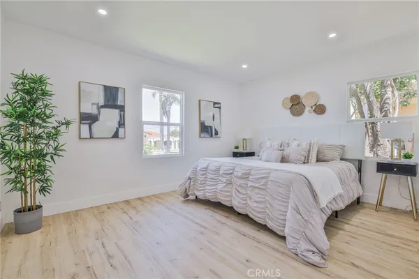 a bedroom with a large bed and a potted plant