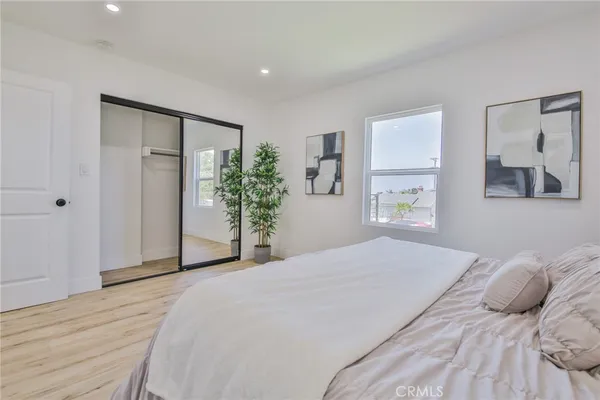 a bedroom with a large bed and a potted plant