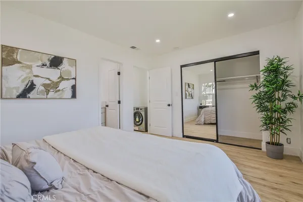 a bedroom with a large bed and a potted plant