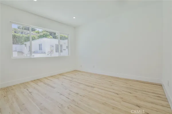 a view of a room with wooden floor and window
