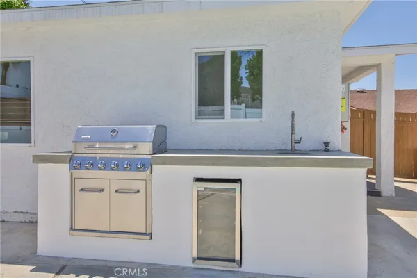a kitchen with a refrigerator a stove a sink dishwasher and a dining table with wooden floor