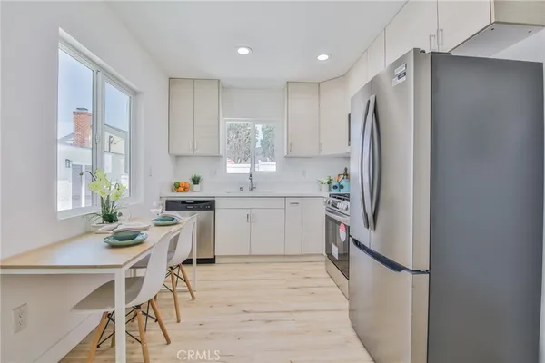 a kitchen with stainless steel appliances a refrigerator sink and white cabinets