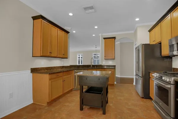 a kitchen with stainless steel appliances granite countertop a stove a sink dishwasher and a microwave oven with cabinets